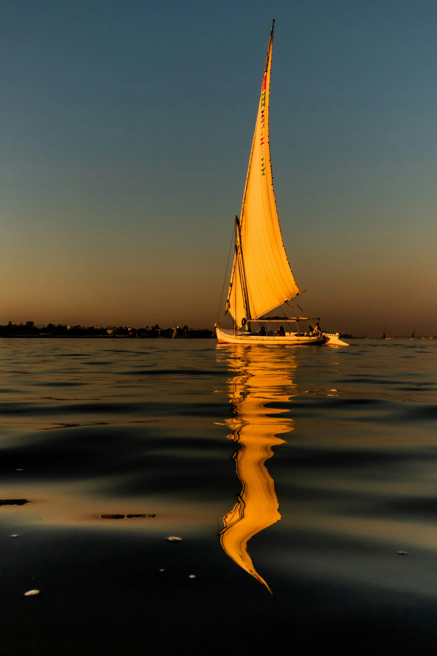 Traditional Egyptian felucca sailing the Nile at golden hour